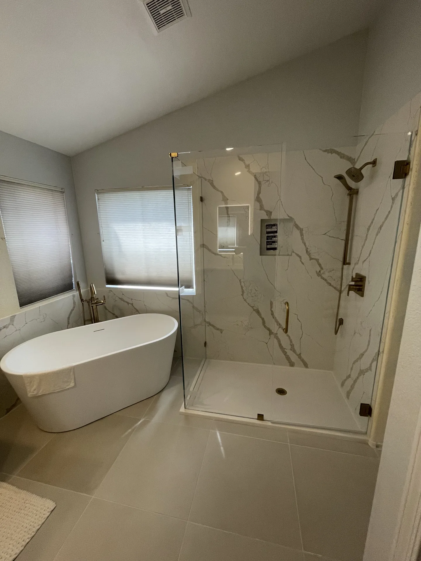 Remodeled primary bathroom with a freestanding tub and glass walk-in shower by Orange Cactus Remodeling, serving Tempe, AZ