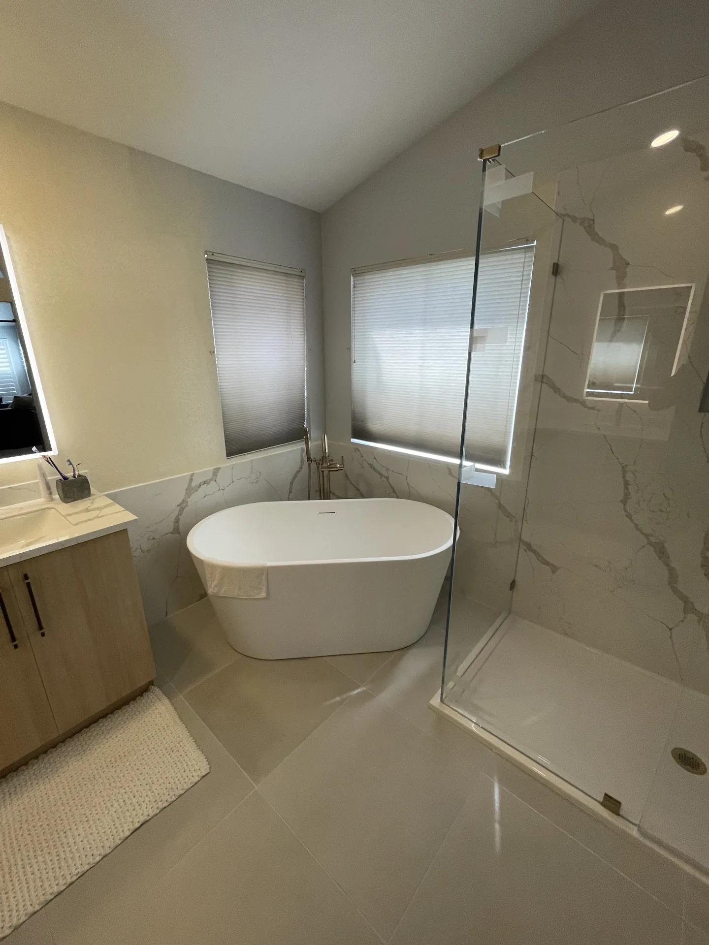 Modern bathroom remodel with a soaking tub, floating vanity, and marble-look tile by Orange Cactus Remodeling, serving Tempe, AZ