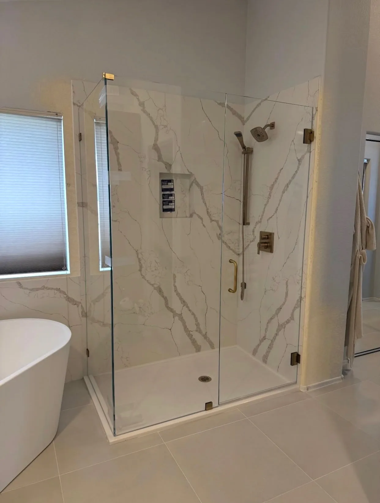 Home remodeling in Scottsdale, AZ by Orange Cactus Remodeling, a marble-look walk-in shower with a freestanding soaking tub
