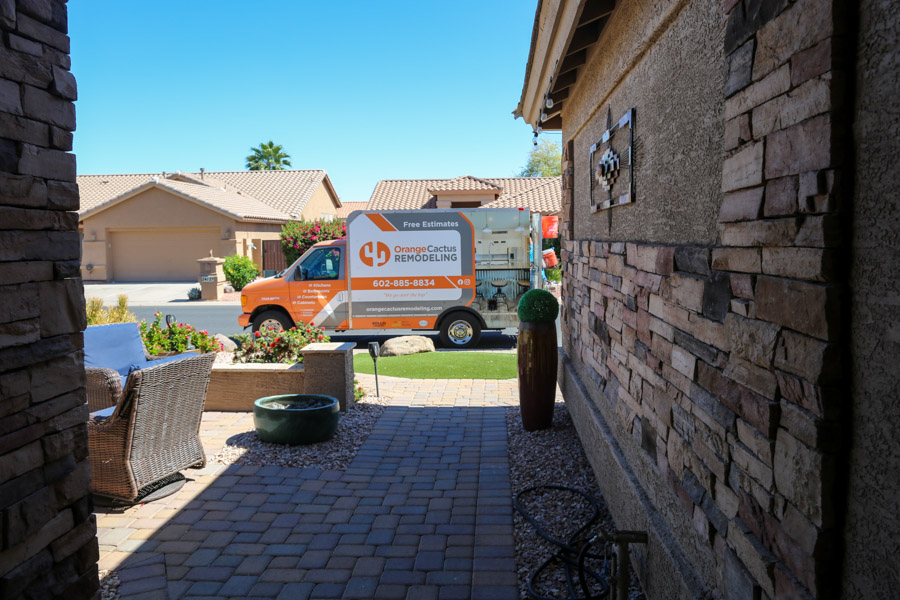 Orange Cactus Remodeling van parked outside a stone-front desert home, whole-home remodeling serving Scottsdale, AZ