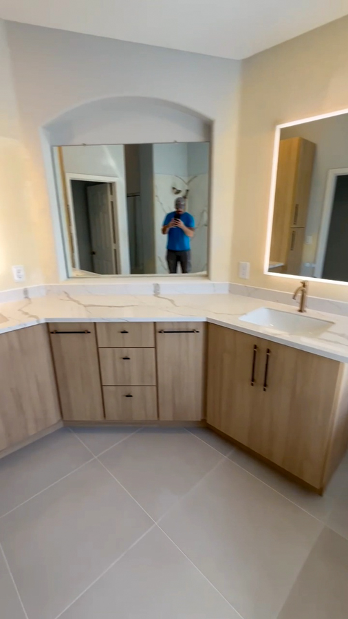Bathroom vanity with quartz counters, wood-tone cabinetry, and an LED mirror, remodeled by Orange Cactus Remodeling, serving Scottsdale, AZ