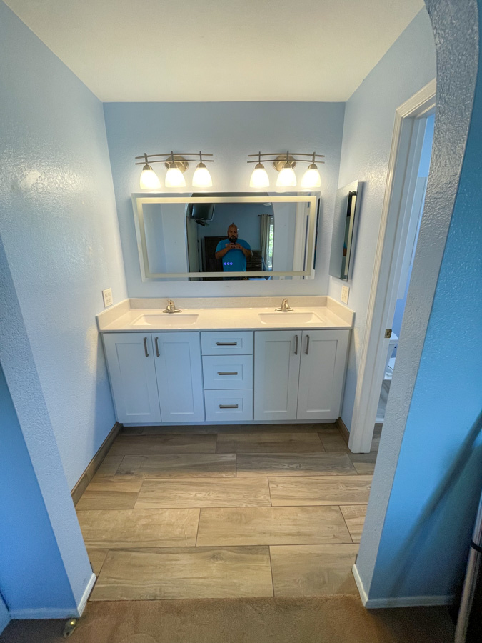 Remodeled bathroom with a double vanity, quartz counter, and wood-look tile flooring by Orange Cactus Remodeling, serving Mesa, AZ