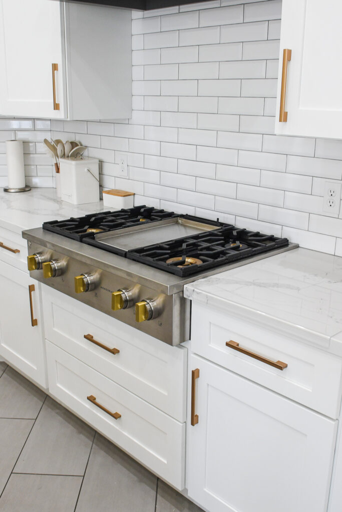 Kitchen remodel in Chandler AZ with white cabinets, tile backsplash, and gas range
